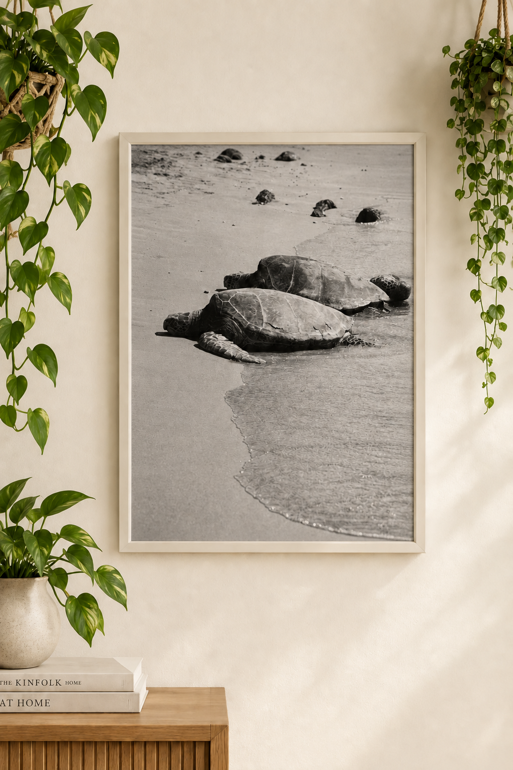 Black-and-white sea turtle photograph without a white border inside a cream frame surrounded by green plants