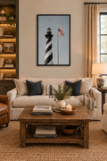 Striped lighthouse and American flag print without a white border in a black frame above a sofa